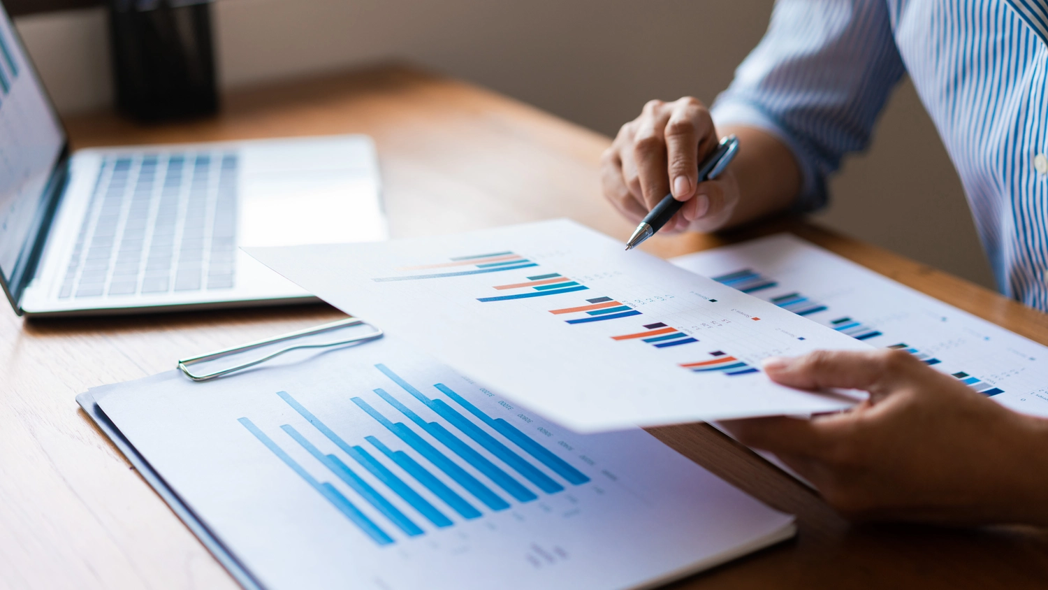 BD Medical Writing & Consulting - Nahaufnahme der Hände eines Geschäftsmannes, der ein Finanzdokument und eine Analyse zur Geschäftsstrategie liest.